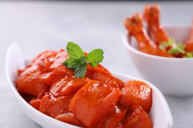 Çiğ salamura edilmiş tavuk küpleri ve bagetler beyaz bir seramik sofra takımına yerleştirilmiş. Taze kişniş yaprağı ile süslenmiş. Gri beyaz desenli arka plan üzerine yerleştirilmiş..