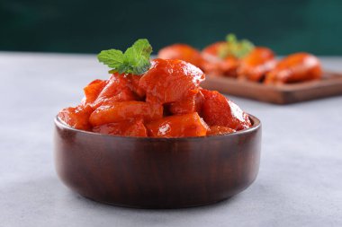 Çiğ terbiye edilmiş tavuk küpleri ve bagetler ahşap bir sofra takımına yerleştirilmiş taze nane yaprağıyla süslenmiş gri beyaz dokuya ve koyu yeşil arka plana yerleştirilmiş, seçici odaklı..