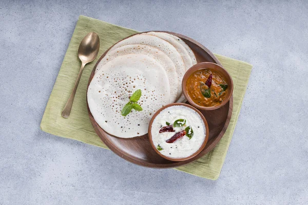 南印度传统早餐多萨或Thattu Dosa 用铁制的多萨或多萨制成 摆放在一个餐具柜中 旁边有白菜 椰子酱和白质背景的洋葱 — 图库照片