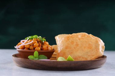 Hint kahvaltısı _ Poori ile nohut chana masala körisi, lezzetli Hint yemeği ahşap bir tabakta ahşap arka planda sıralanmış buğday unu ile yapılır.