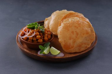 Hint kahvaltısı _ Poori ile nohut chana masala körisi, lezzetli Hint yemeği her amaçlı buğday unu kullanılır ahşap bir tabakta gri desenli arka plan ile düzenlenir.