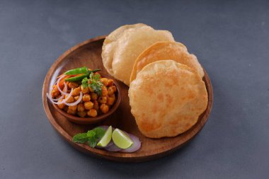 Hint kahvaltısı _ Poori ile nohut chana masala körisi, lezzetli Hint yemeği her amaçlı buğday unu kullanılır ahşap bir tabakta gri desenli arka plan ile düzenlenir.