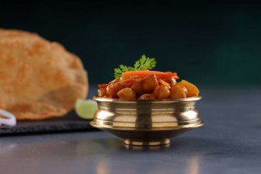 Hint kahvaltısı _ Poori ile nohut chana masala körisi, lezzetli Hint yemeği buğday unu ve Hint körisi ile gri desenli bir kapta sıralanmış, seçici odaklı.