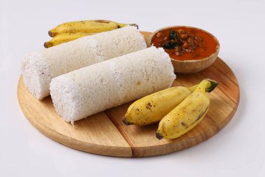 Puttu / Çiğ pirinç puttu / Arisi Maavu Puttu ve chana körili / kadala körili-Kerala özel kahvaltı öğeleri, çiğ pirinç unu kullanılarak yapılan, beyaz arkaplanda muz ve ahşap bir zeminde yerleştirilmiş ideal bir kombinasyon.