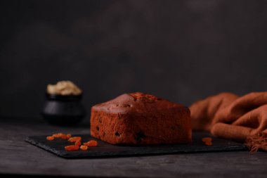 Erikli kek, ev yapımı lezzetli noel pastası. Kuru üzüm, fındık ve kurutulmuş meyve kullanarak. Gri arkaplanlı ve izole edilmiş bir grafit tabanına yerleştirilmiş..