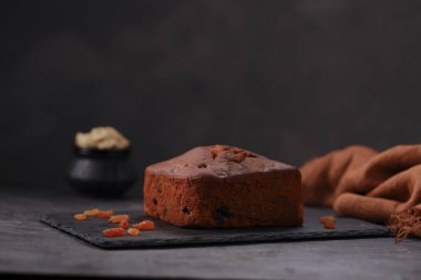 Erikli kek, ev yapımı lezzetli noel pastası. Kuru üzüm, fındık ve kurutulmuş meyve kullanarak. Gri arkaplanlı ve izole edilmiş bir grafit tabanına yerleştirilmiş..