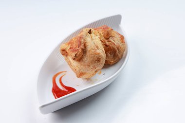 Baharatlı ve lezzetli yumurta masala ile doldurulmuş yumurtalı börek ve beyaz desenli arka planda domates soslu beyaz bir sofra takımı..