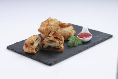 Baharatlı ve lezzetli yumurta masala ile doldurulmuş yumurta puf böreği ve beyaz desenli arka plan ile grafit tahtaya yerleştirilmiş, izole