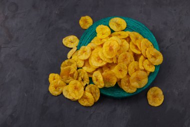 Kurutulmuş muz cipsi ya da muz waffle 'ı, gri desenli, izole edilmiş yeşil bir zemine saçılmış..