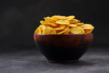 Kurutulmuş muz cipsi ya da muz waffle 'ı. Gri desenli arka plan ve izole bir toprak kaplamasında güzelce sıralanmış..