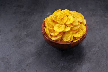Kurutulmuş muz cipsi ya da muz waffle 'ı. Gri desenli arka plan ve izole bir toprak kaplamasında güzelce sıralanmış..