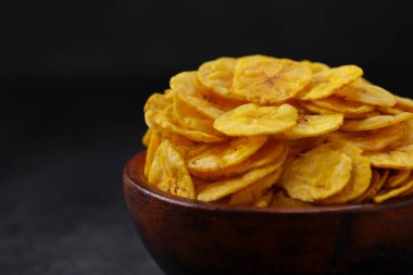 Kurutulmuş muz cipsi ya da muz waffle 'ı. Gri desenli arka plan ve izole bir toprak kaplamasında güzelce sıralanmış..