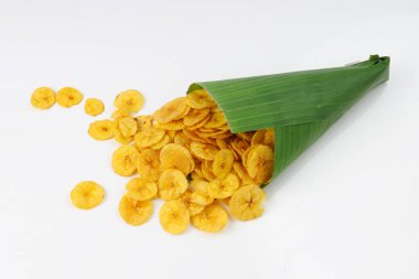 Kurutulmuş muz cipsi ya da muz waffle 'ı muz yaprağı konisinden beyaz desenli arka plana dökülmüş..