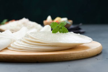 Pirinç Pathiri ve Ideyappam, Güney Hindistan Malabar özel kahvaltısı beyaz pirinç unu kullanılarak, gri desenli arka plan ile ahşap bir zeminde sıralanmış..