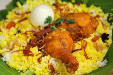 Tavuk biryani, kerala stili tavuk dhum biryani jeera pilavı ve baharatlar kullanılarak yapıldı. Beyaz arka planlı, izole edilmiş kırmızı bir masa takımında.