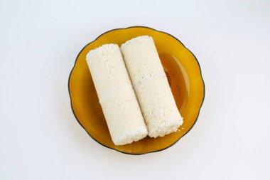 Puttu ya da Beyaz pirinç puttu Kerala özel kahvaltı malzemeleri pirinç unu ile yapılır ve çok sağlıklıdır ve beyaz desenli arka planda bir sofra takımında düzenlenir.