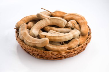 Tamarind _ fasülyesi tohumlarla dolu tohumlar gibidir. Etrafı lifli bir hamurla çevrilidir. Beyaz desenli arka planda bir sepette düzenlenmiştir..