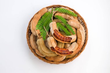 Tamarind _ fasülyesi tohumlarla dolu tohumlar gibidir. Etrafı lifli bir hamurla çevrilidir. Beyaz desenli arka planda bir sepette düzenlenmiştir..