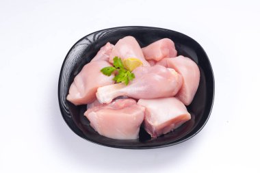 Çiğ tavuk biryani derisiz kesilmiş siyah kabın üzerine yerleştirilmiş ve kişniş yaprağı ile süslenmiş.