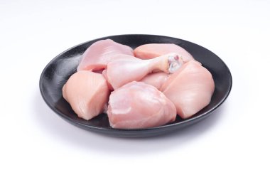 Çiğ tavuk derisiz köri, beyaz desenli arka planda siyah tabakta sıralanmış.