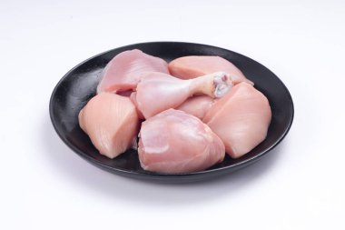 Çiğ tavuk derisiz köri, beyaz desenli arka planda siyah tabakta sıralanmış.