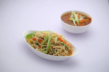 Tavuk Hakka Eriştesi ve biberli tavuk, Çin yemeği tarifi oval şekilli beyaz kâse ve beyaz dokuma ile soslu kırmızı biberli soslu tavuk.