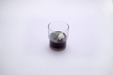 Krem şantili siyah çikolatalı mus, servis bardağında beyaz desenli.