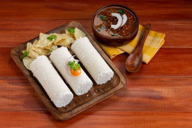 Puttu, Raw Rice puttu, Arisi Maavu Puttu chana ya da Bengal gramı körili kahvaltı öğeleri, çiğ pirinç unu kullanılarak yapılmış, kahverengi ahşap tabanlı ideal bir kombinasyon. 