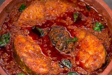 Kahin Balığı ya da Kral Balık Köri, geleneksel Hint balık körisi, Kerala tarzı ya da Kottayam stili yemek, köri yaprakları ve gri bir arka planda Malabar demiriyle süslenmiş toprak kaplama kaplamasında..