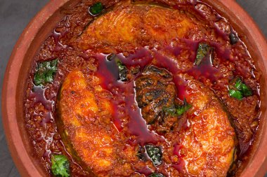 Kahin Balığı ya da Kral Balık Köri, geleneksel Hint balık körisi, Kerala tarzı ya da Kottayam stili yemek, köri yaprakları ve gri bir arka planda Malabar demiriyle süslenmiş toprak kaplama kaplamasında..