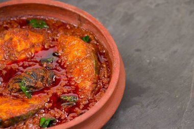 Kahin Balığı ya da Kral Balık Köri, geleneksel Hint balık körisi, Kerala tarzı ya da Kottayam stili yemek, köri yaprakları ve gri bir arka planda Malabar demiriyle süslenmiş toprak kaplama kaplamasında..