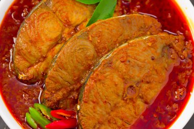 Kahin Balığı ya da Kral Balık Köri, geleneksel Hint balık körisi, Kerala tarzı ya da Kottayam stili yemek, köri yaprakları ve gri bir arka planda Malabar demiriyle süslenmiş toprak kaplama kaplamasında..