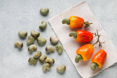 Kaju elması ve kaju tohumları gri desenli arka plana yerleştirilir..