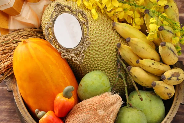 Kerala festival,rituals of Vishu festival -Vishukkani or Vishu sight, a brass vessel  filled with fruits,vegetable, paddy,mirror,golden shower flower and new cloth  arranged  traditionally with fruits and vegetables mostly  available in this season.