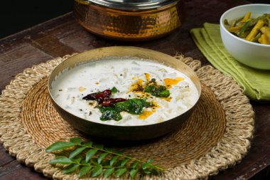 Pachadi veya Raitha ve olan _ Kerala ziyafet mezeleri, pirinç bir kap ve ahşap arka plana yerleştirilmiş beyaz kase içinde düzenlenmiş vejetaryen gıda öğeleri.