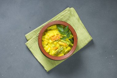 Avial _ Kerala geleneksel meze, karışık sebzelerle yapılır ve çok sağlıklı ve lezzetli bir yemektir, gri arkaplanlı bir toprak tabaktadır.