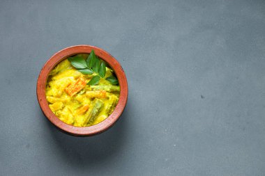 Avial _ Kerala geleneksel meze, karışık sebzelerle yapılır ve çok sağlıklı ve lezzetli bir yemektir, gri arkaplanlı bir toprak tabaktadır.