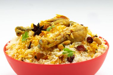 Tavuk biryani, kerala stili tavuk dhum biryani jeera pilavı ve baharatlar kullanılarak yapıldı. Beyaz arka planlı, izole edilmiş kırmızı bir masa takımında.