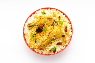 Tavuk biryani, kerala stili tavuk dhum biryani jeera pilavı ve baharatları kullanarak beyaz arka planda, izole edilmiş ve üst manzaralı kırmızı bir masa takımına yerleştirilmiş.
