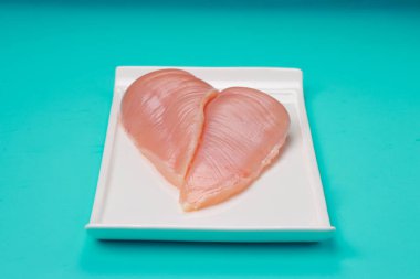 Derisiz çiğ tavuk göğsü fileto beyaz dikdörtgen şekilli düz masa takımı ve buz mavisi katı renk arka plan