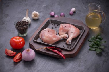 Gri desenli arka planı olan cızırtılı bir cızırtıda dizilmiş taze derisiz tavuk bacakları.. 