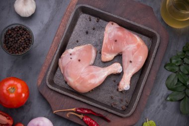 Gri desenli arka planı olan cızırtılı bir cızırtıda dizilmiş taze derisiz tavuk bacakları.. 