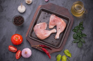 Gri desenli arka planı olan cızırtılı bir cızırtıda dizilmiş taze derisiz tavuk bacakları.. 