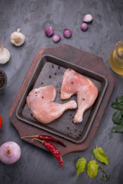 Gri desenli arka planı olan cızırtılı bir cızırtıda dizilmiş taze derisiz tavuk bacakları.. 