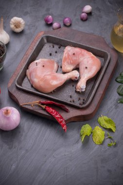 Gri desenli arka planı olan cızırtılı bir cızırtıda dizilmiş taze derisiz tavuk bacakları.. 