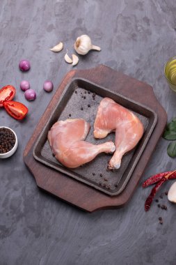 Gri desenli arka planı olan cızırtılı bir cızırtıda dizilmiş taze derisiz tavuk bacakları.. 