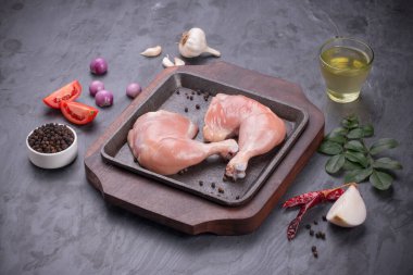 Gri desenli arka planı olan cızırtılı bir cızırtıda dizilmiş taze derisiz tavuk bacakları.. 