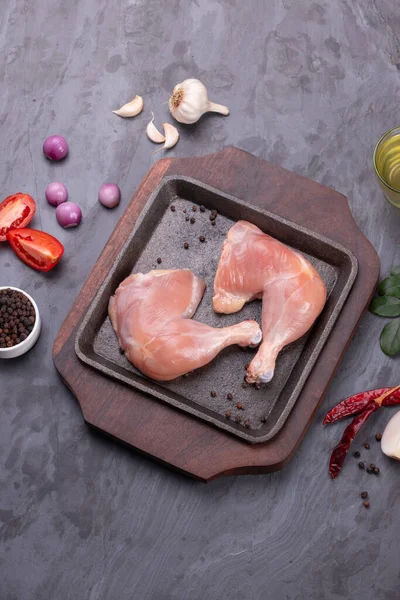 Gri desenli arka planı olan cızırtılı bir cızırtıda dizilmiş taze derisiz tavuk bacakları.. 