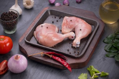 Gri desenli arka planı olan cızırtılı bir cızırtıda dizilmiş taze derisiz tavuk bacakları.. 