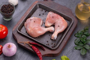 Gri desenli arka planı olan cızırtılı bir cızırtıda dizilmiş taze derisiz tavuk bacakları.. 